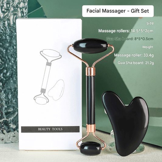 Black facial roller set with heart-shaped gua sha, rose-gold metal ends and handles