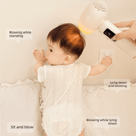 Pink baby hair dryer blowing warm air while held near a baby