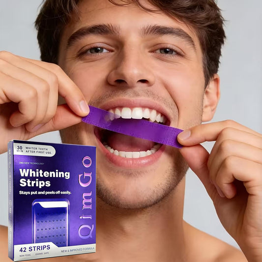 Purple teeth whitening strip held on smiling man’s teeth