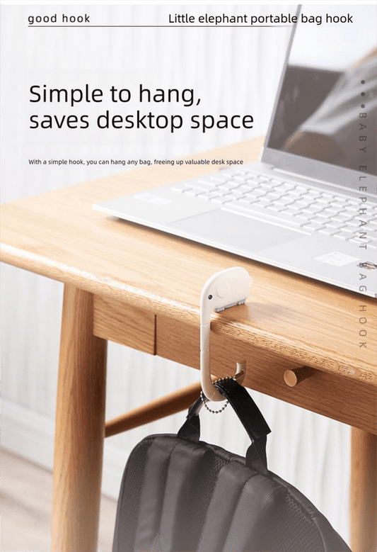 Pink elephant portable bag hook mounted on desk edge, holds a tote bag