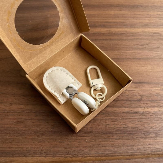 Mini scissors set with safety cap, leather sheath and keychain hook in a box