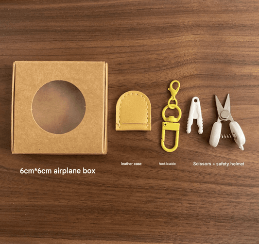 Compact scissors set with leather sheath, yellow keychain hook, and safety cap