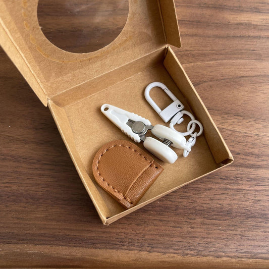 Mini precision scissors set with safety cap, brown leather sheath and keychain hook in box