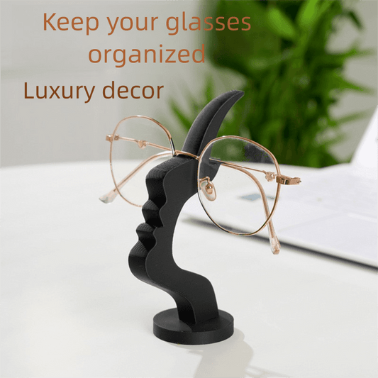Black eyeglass display stand with arched back and eyeglasses on base