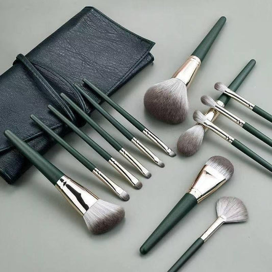 Makeup brush set with storage bag, green handles, silver ferrules, and soft bristles