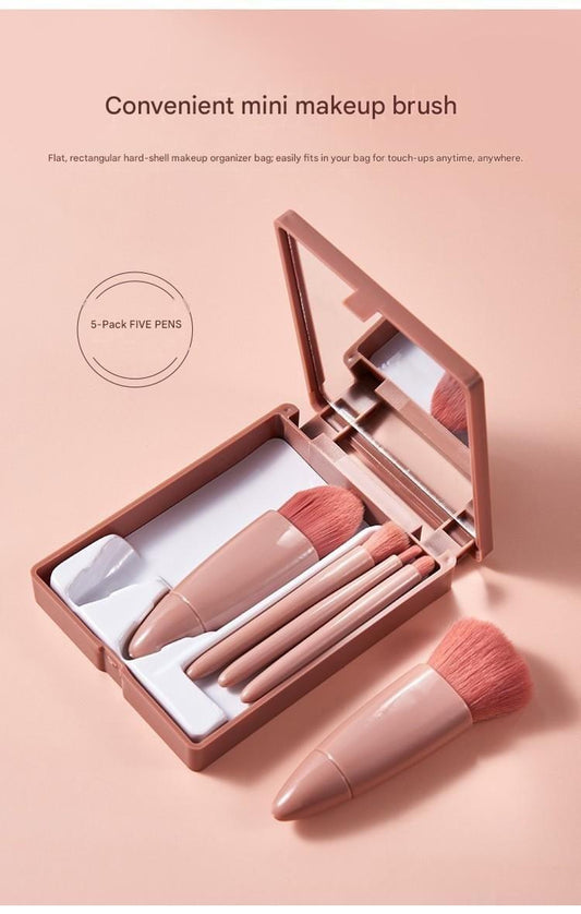 Travel makeup brush case with mirror open, showing five pink brushes and bristles
