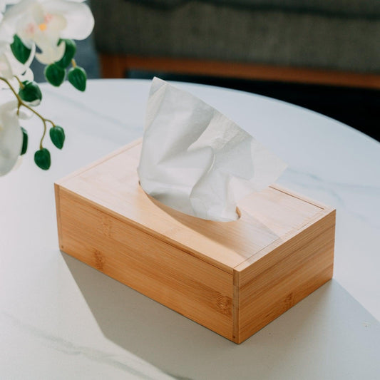 Bamboo tissue box with rectangular base and top slot opening, holding white tissues