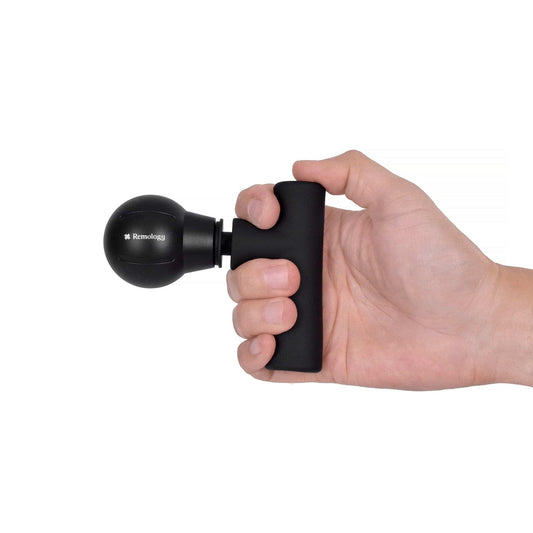 Black mini massage gun held in hand, showing round head and flat front panel