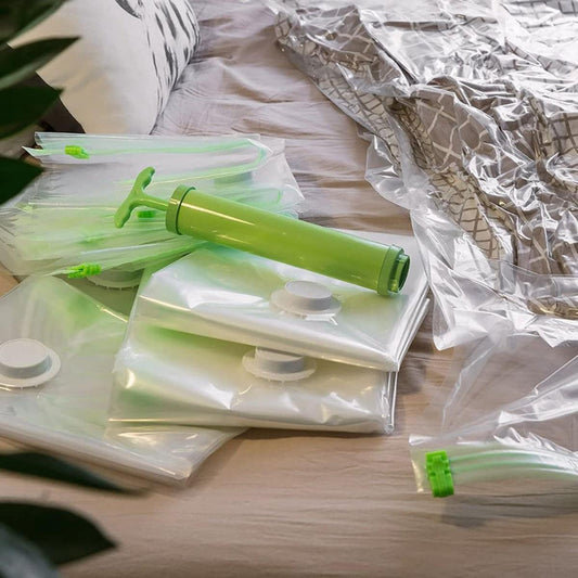 Vacuum storage bags on bedding with green manual inflation tube and valve