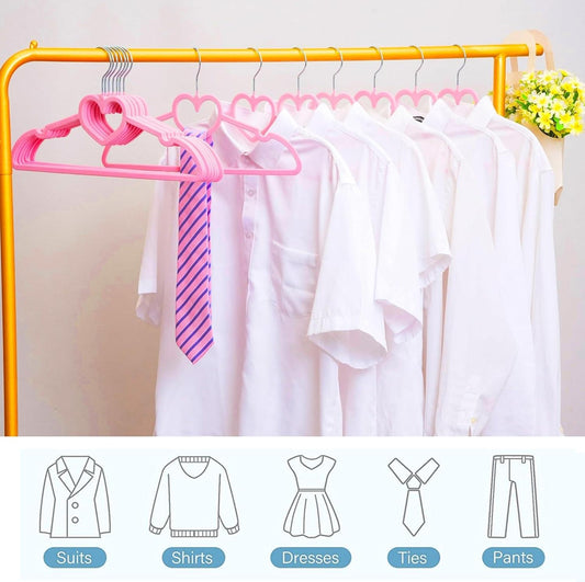 Pink velvet hangers holding white shirts on a closet rail, non-slip heart design