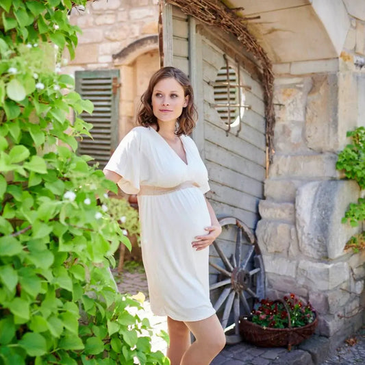 Maternity compression stockings on legs under a light dress outdoors