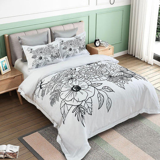 Floral quilt cover set on a bed: white background with black line-art blooms and pillows