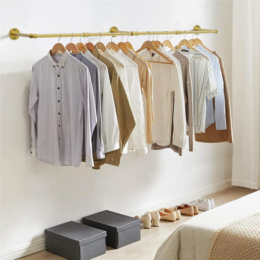 Gold wall-mounted garment rail with multiple shirts hanging on wooden hangers