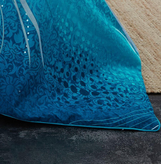 Teal duvet cover with dark blue ornate pattern and stitched edge