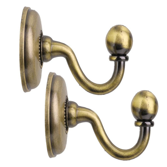 Metal curtain holdback hooks with curved arms and spherical finials on round wall bases