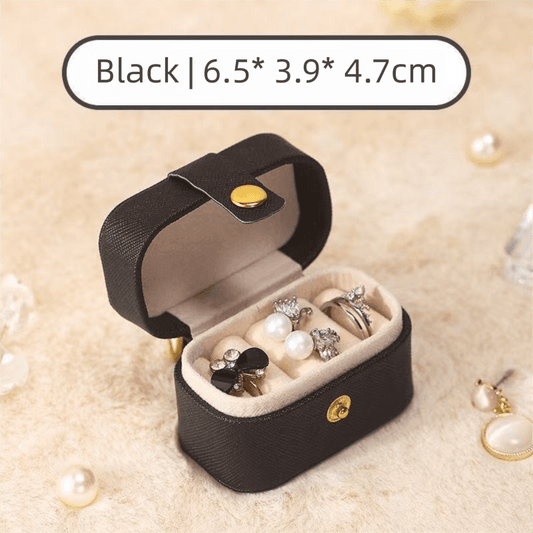 Black mini jewelry travel case open with padded compartments for rings and earrings