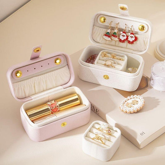 Set of white jewelry organizer boxes with partitions, holding rings and bracelets
