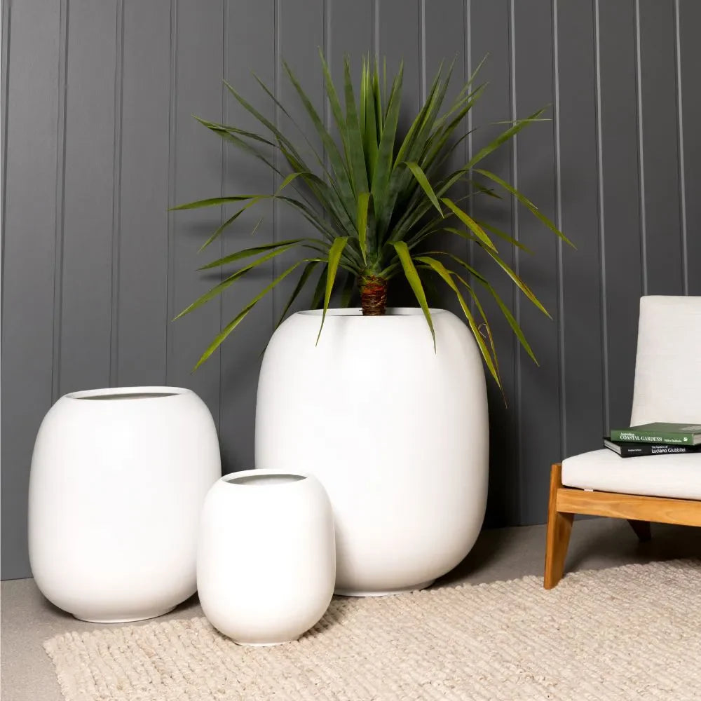 Matte white ceramic vase set of three with open tops and rounded, smooth bodies
