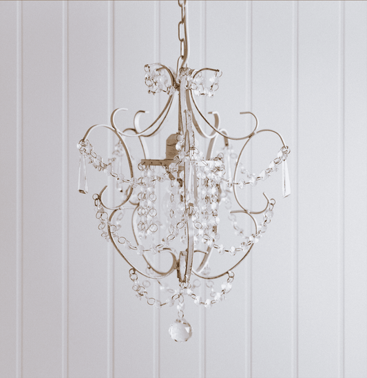 Clear crystal chandelier with ornate metal arms and hanging crystal drops