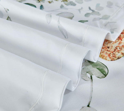 White quilt cover fabric close-up with stitched edge and botanical print