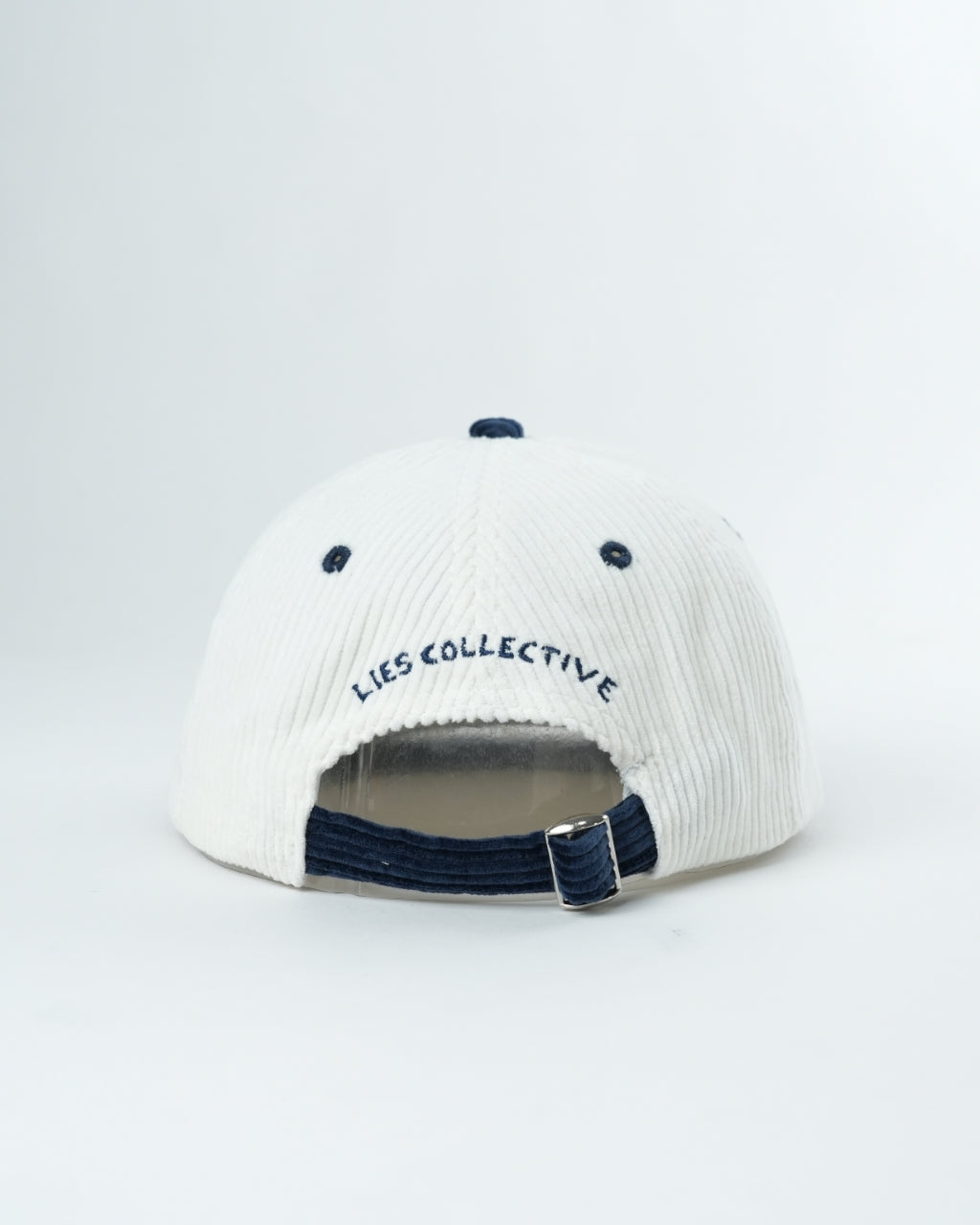 White knit cap with navy brim, LIES COLLECTIVE lettering, and adjustable strap back