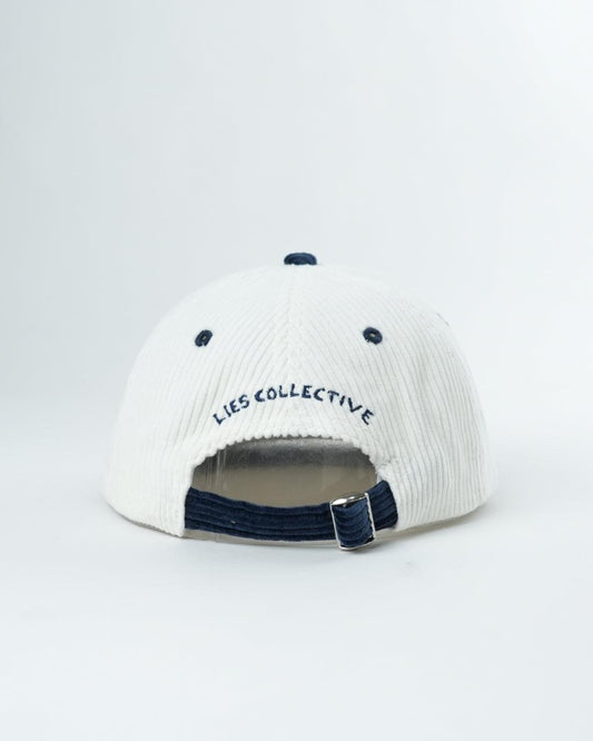 White knit cap with navy brim, LIES COLLECTIVE lettering, and adjustable strap back