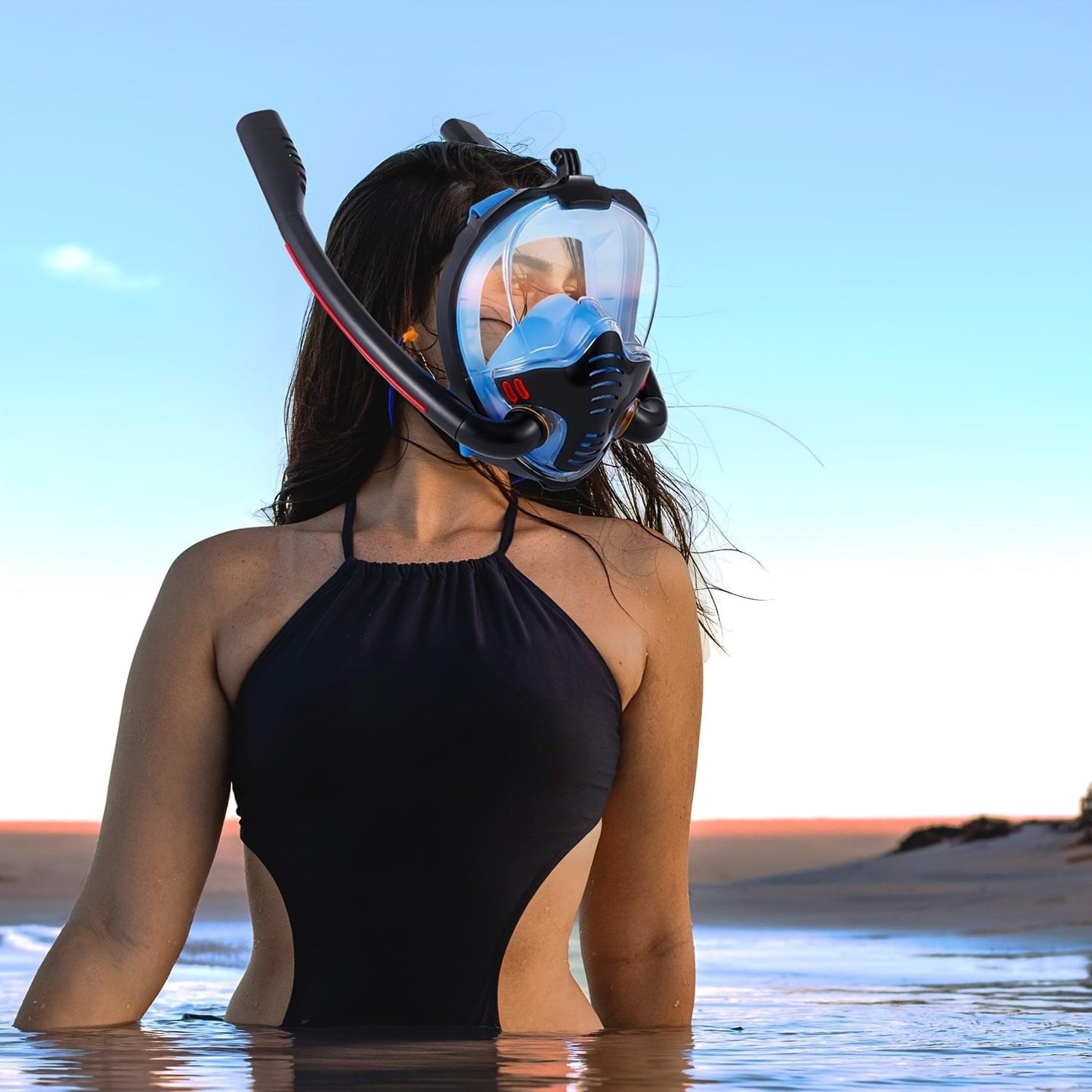 Full-face snorkel mask with black frame and clear visor on swimmer, snorkel tube visible