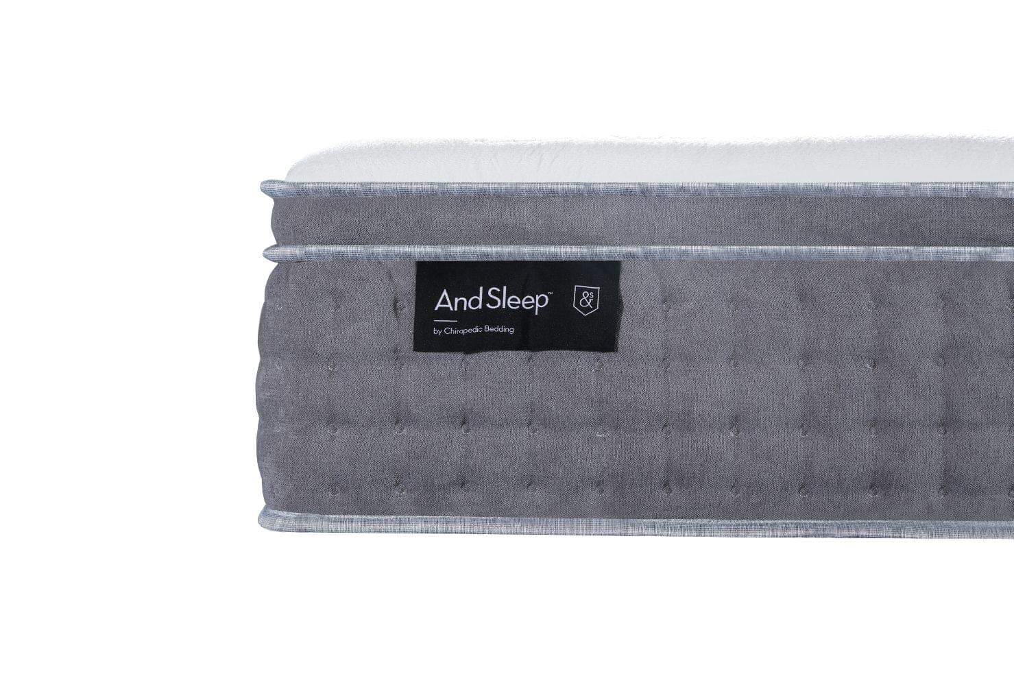 Gray mattress with tufted side panel and black And Sleep label