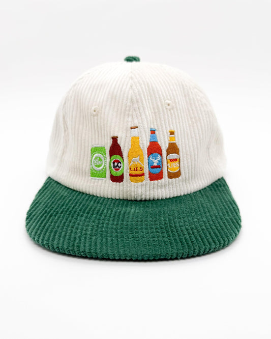 Cream corduroy cap with green brim and beer bottle patches on front