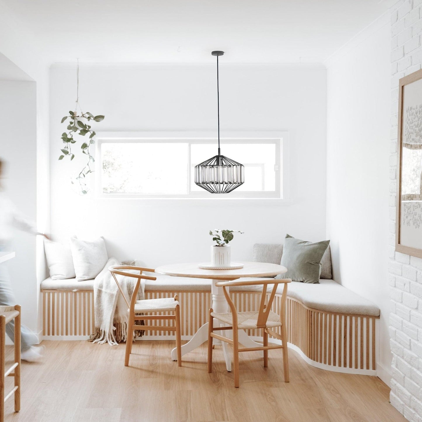 Black prism glass pendant light above dining table with ribbed clear glass shade