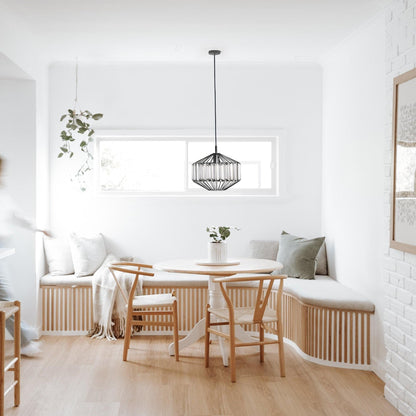 Black prism glass pendant light above dining table with ribbed clear glass shade