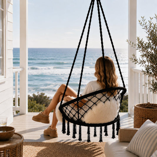 Black macrame hanging chair swing with white faux-fur cushion and fringe tassels