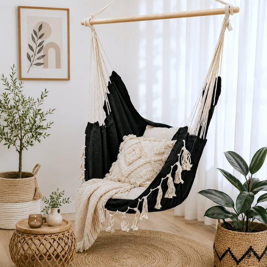 Black hanging hammock chair with beige cushion and cream macrame tassel fringe