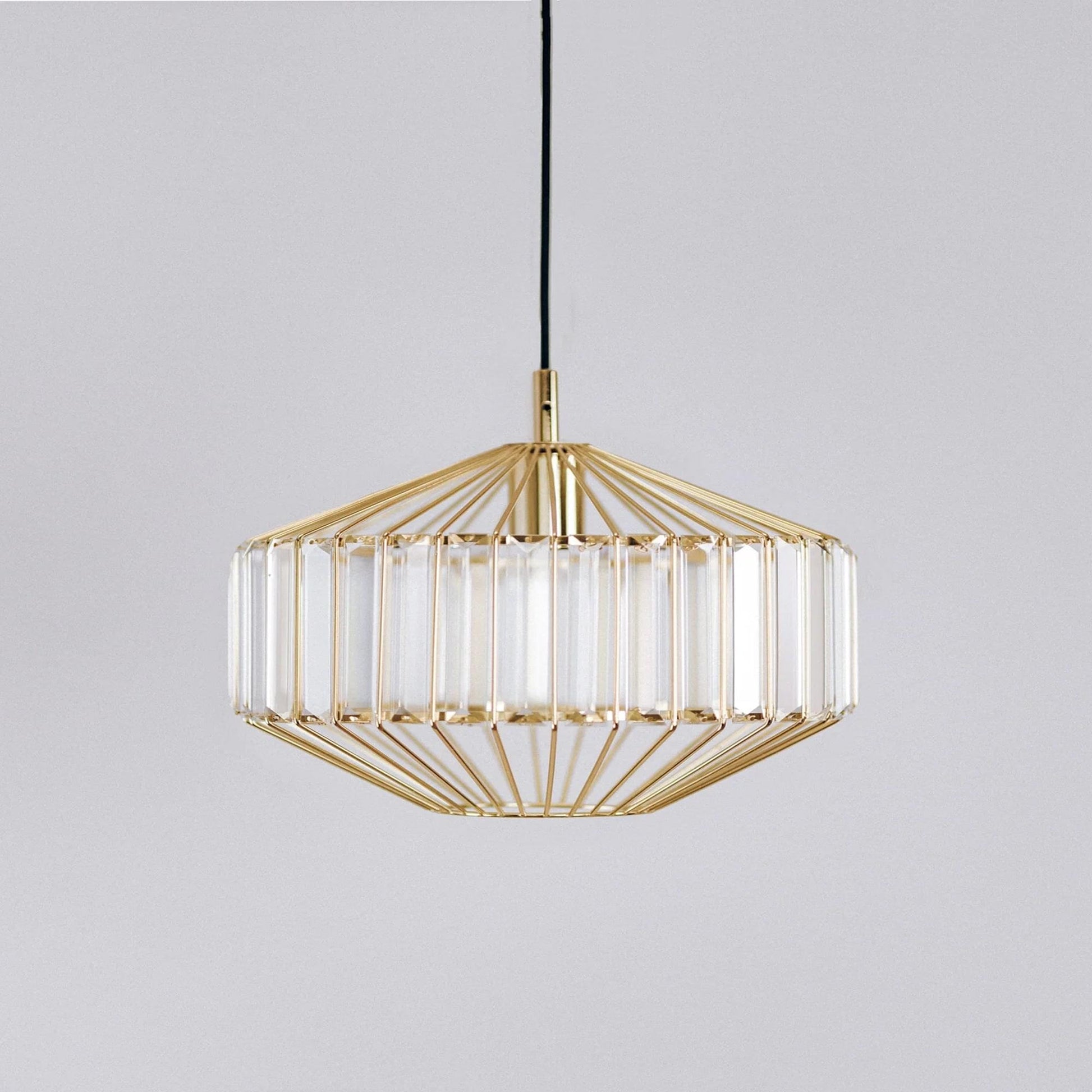 Gold prism glass pendant light with faceted clear panels and gold frame, hanging