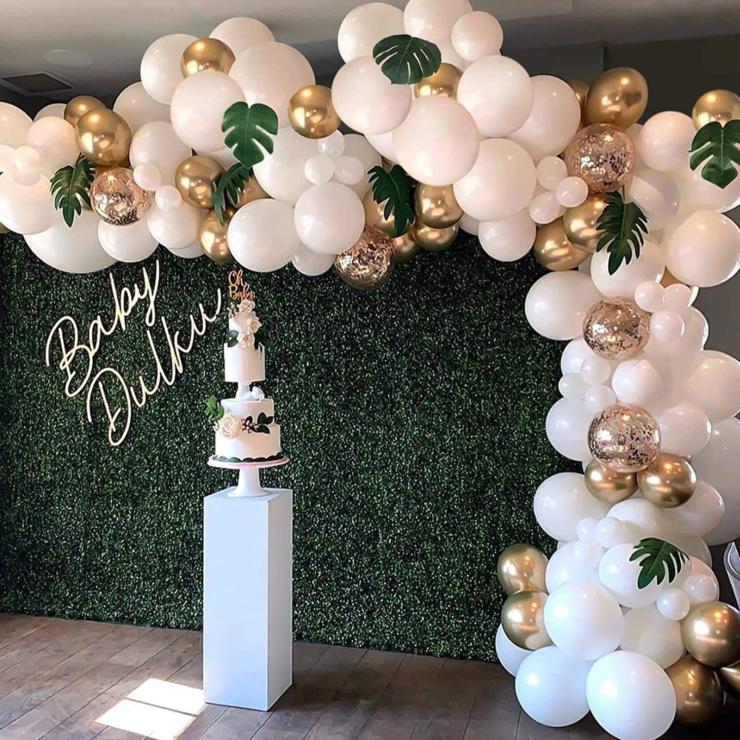 White balloon arch kit with gold and metallic balloons and green leaf accents