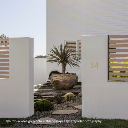 Exterior house number plaque 34 on white stucco wall