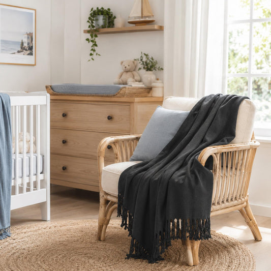 Charcoal bamboo throw blanket draped over armchair with fringe tassels