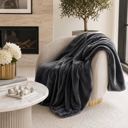 Charcoal gray plush throw blanket draped over armchair