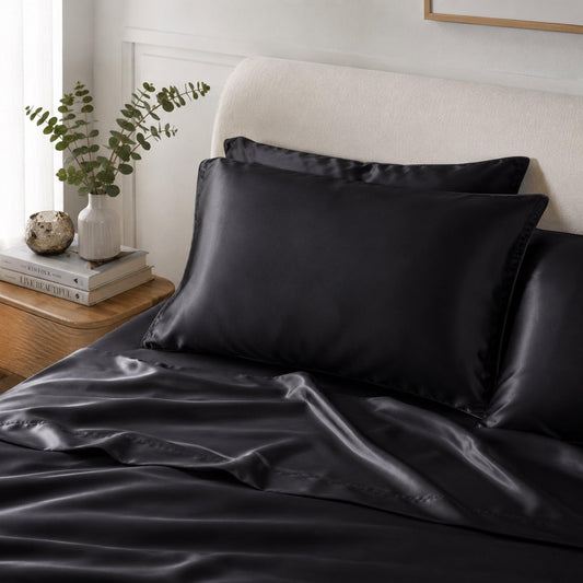 Charcoal satin pillowcase on a bed with crisp envelope closure and glossy sheen.