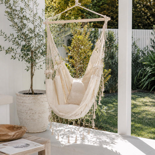 Cream hammock hanging chair with fringe and seat cushion