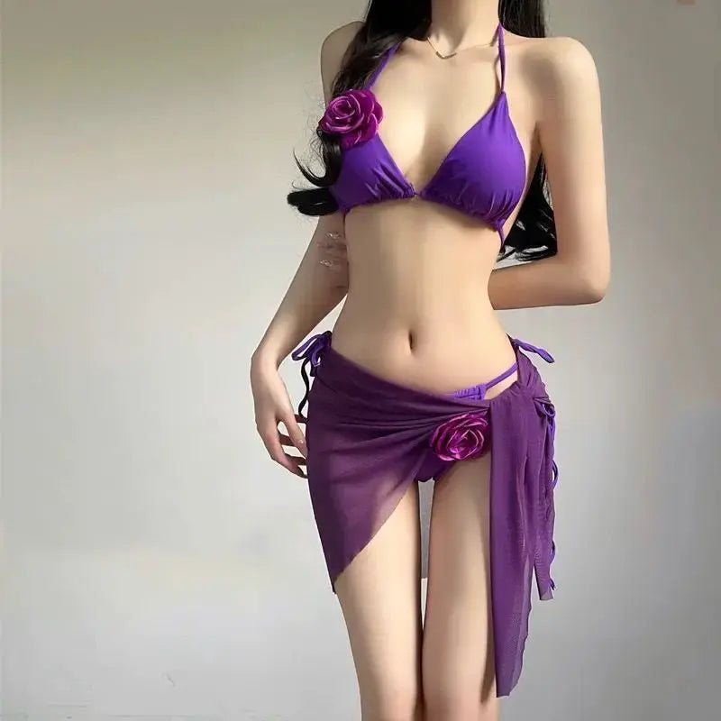 Purple strappy bikini set with padded triangle top, rose detail, and draped wrap skirt
