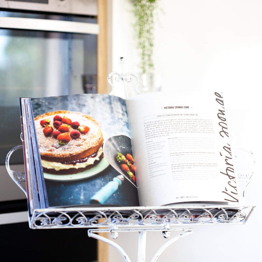 White metal book and menu stand holding an open cookbook