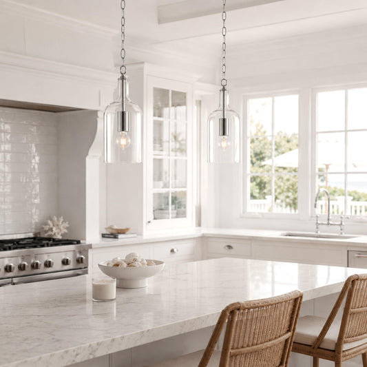 Set of chrome pendant lights with clear glass shades hanging over kitchen counter