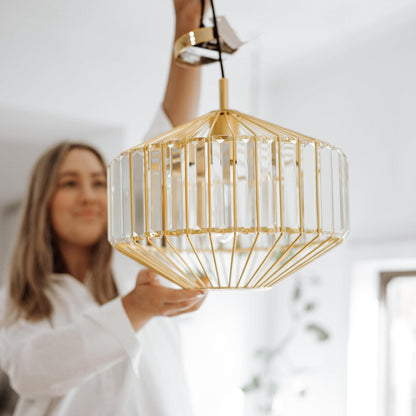 Gold prism glass pendant light with faceted clear panels, close-up view of shade