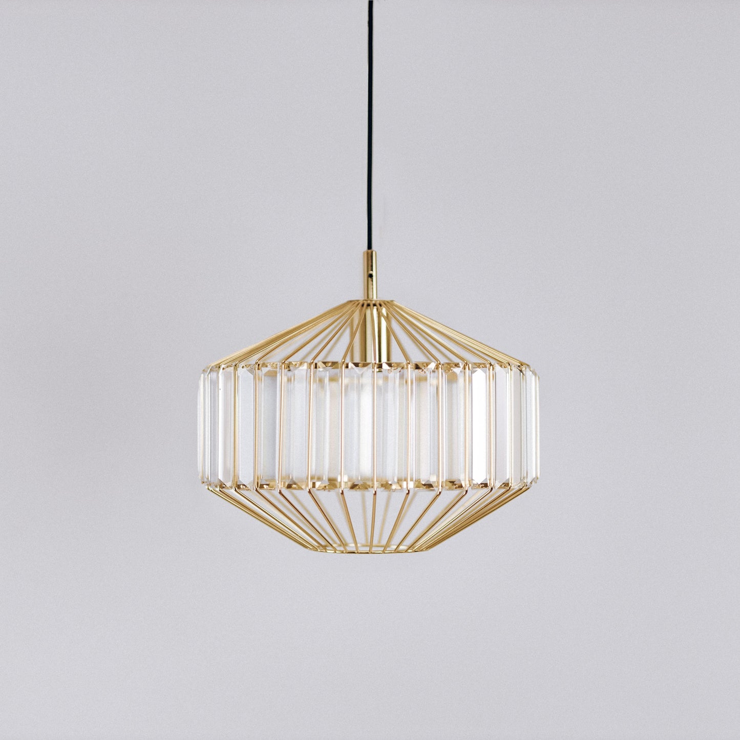 Gold prism glass pendant light with clear ribbed prism panels, centered front view