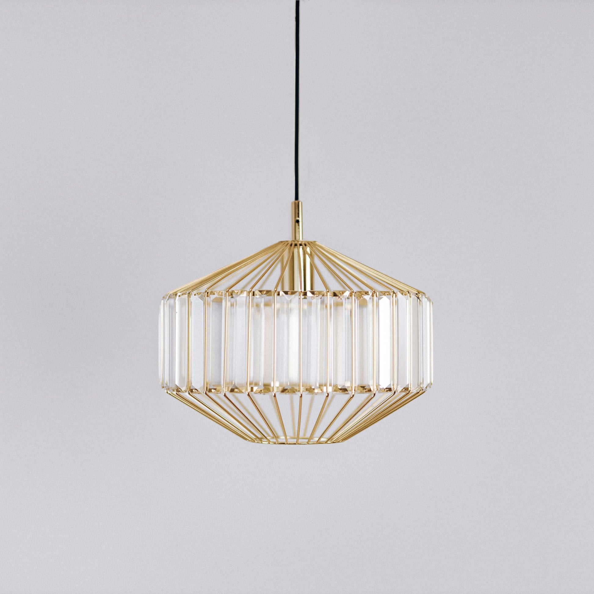 Gold prism glass pendant light with clear ribbed prism panels, centered front view