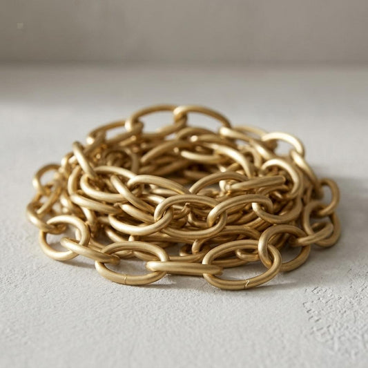 Gold-tone oval link chain extension, brushed brass chain coiled