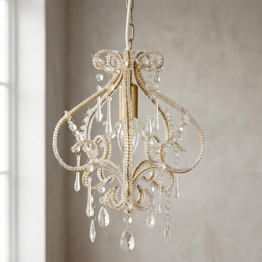 Gold chandelier with ornate scroll arms and hanging clear crystal bead drops