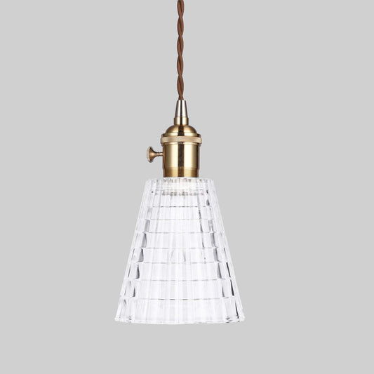 Glass pendant light with ribbed clear shade and antique brass socket, braided cord.