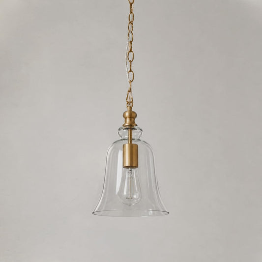 Gold bell-shaped glass pendant light with clear shade and hanging chain.